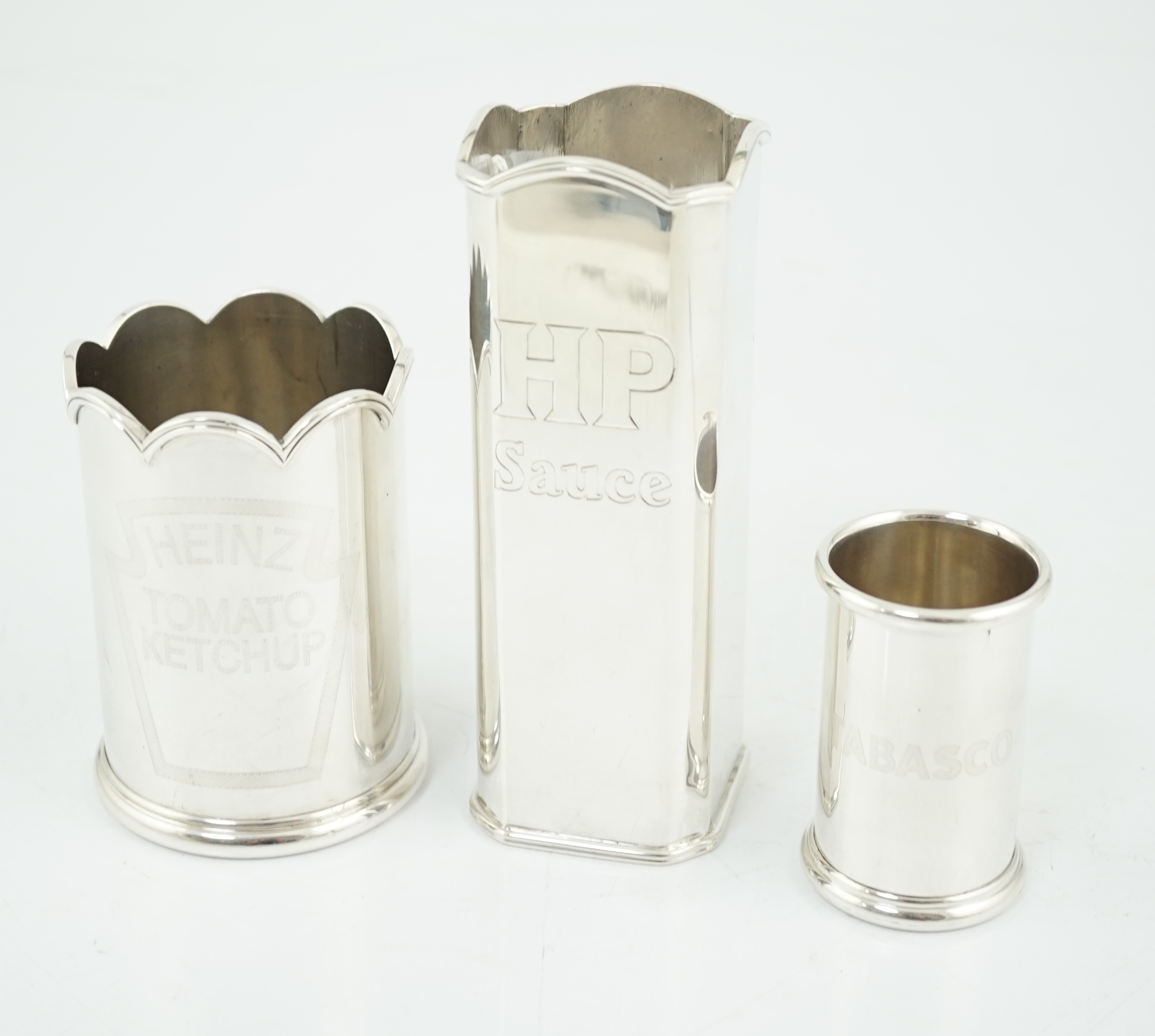 Three assorted Elizabeth II Theo Fennell silver bottle holders
